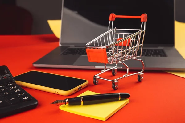 Concetto di shopping online con carrello e smartphone con laptop. Mercato dell'e-commerce. Trasporto logistico. Commercio al dettaglio — Foto Stock