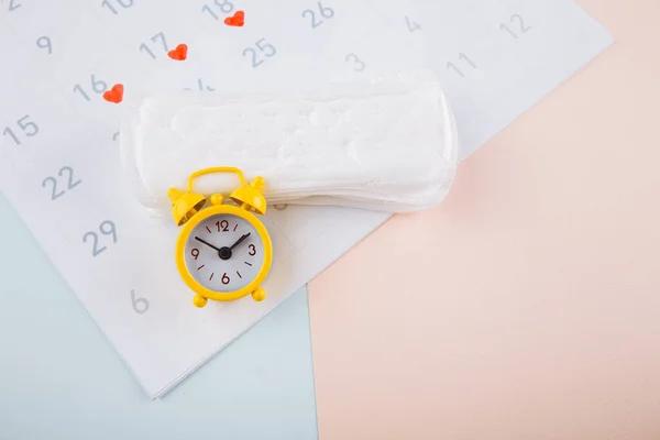 Menstruációs naptár sárga riasztóval és napi betétek rózsaszín alapon. Női kritikus napok, női higiénia védelmi koncepció — Stock Fotó