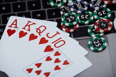 Poker kartları ve dizüstü bilgisayarda yığınla poker fişi. Poker çevrimiçi kavramı