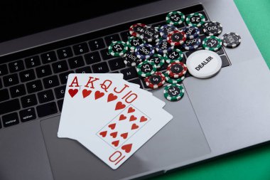 Çevrimiçi poker teması. Kumar fişleri ve dizüstü bilgisayarda kumar kartları