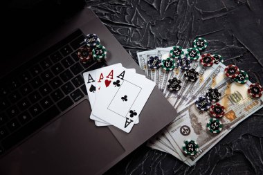 Çevrimiçi poker teması. Kumar fişleri ve dizüstü bilgisayarda kumar kartları