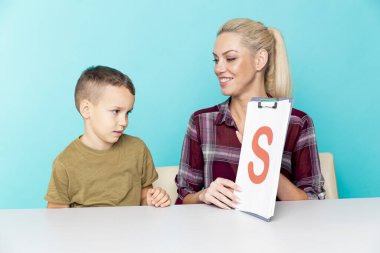 Annesiyle ödev yapan küçük bir okul çocuğu, aile içi işbirliği, ebeveynlik.