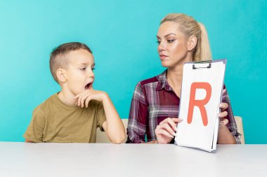 Annesiyle ödev yapan küçük bir okul çocuğu, aile içi işbirliği, ebeveynlik.