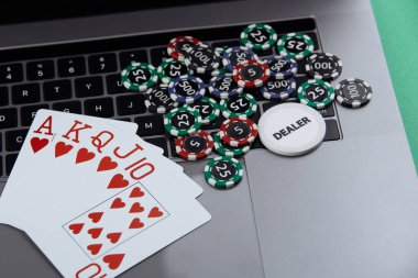 Poker kartları ve dizüstü bilgisayarda yığınla poker fişi. Poker çevrimiçi kavramı