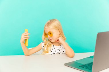 Evde kameranın önünde vlog için konuşan mutlu kız. çocuk kendi fotoğrafını ve videosunu çekiyor blog yazarı olarak çalışıyor, internet için video dersi kaydediyor.