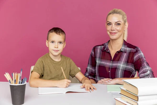 ピンクの部屋で一緒に宿題をする子供との講師. — ストック写真