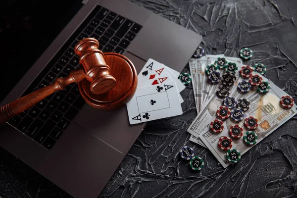 Online gambling and justice theme, cards, playing chips and judge gavel on laptop keyboard