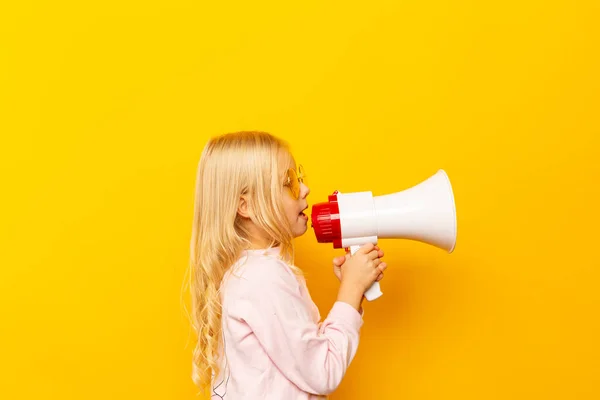 Kind schreit durch Megafon. Kommunikationskonzept. gelber Hintergrund als Kopierraum für Ihren Text — Stockfoto