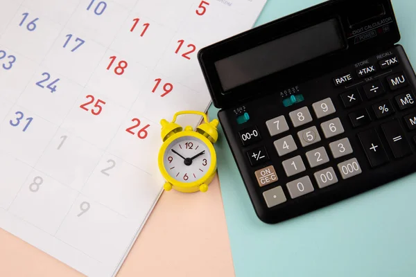 Väckarklocka, miniräknare och kalender - affärs- eller skattetidskoncept — Stockfoto