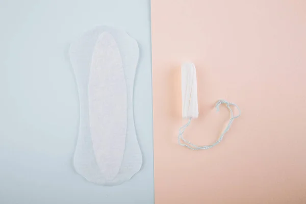 Concetto di igiene delle donne mestruazioni. Minimale piatto laici tampone mestruale e tampone di cotone su uno sfondo rosa blu — Foto Stock