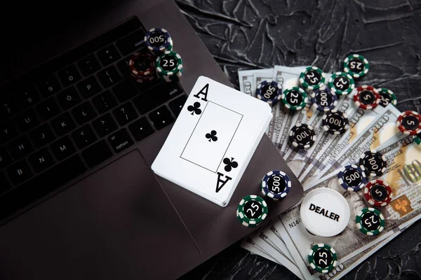 Kartu poker dan tumpukan chip poker di komputer laptop. Konsep online Poker Stok Lukisan  