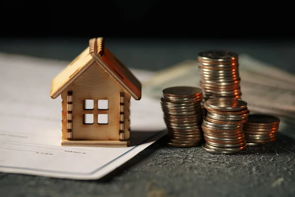Visa av mynt stack med hus modell på grön bakgrund, sparplaner för bostäder, finansiellt koncept, inteckning lastning fastighet med lån pengar bank koncept.Property Tax — Stockfoto