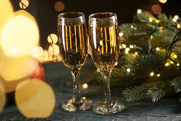 Wstążka, bombki i wino przeciwko lampkom świątecznym — Zdjęcie stockowe