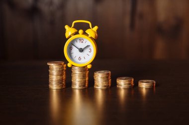 Para yığını ve ahşap arka planda sarı alarmlı işletme finansal fikirleri kavramı