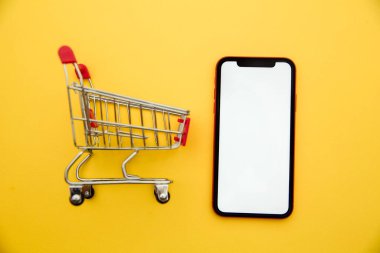 Akıllı telefon ve tramvay sarı arka planda. Online mağazadan eve mal teslimatı konsepti