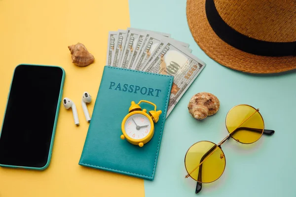 Conceito de turismo. Óculos de sol, smartphone, chapéu e passaporte em fundo azul amarelo — Fotografia de Stock