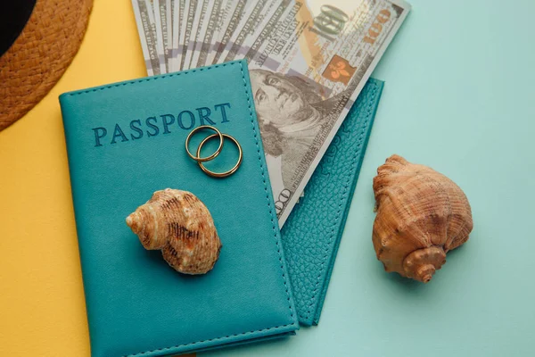 Concepto de viaje de luna de miel. Pasaportes con dinero y conchas sobre un fondo azul amarillo —  Fotos de Stock