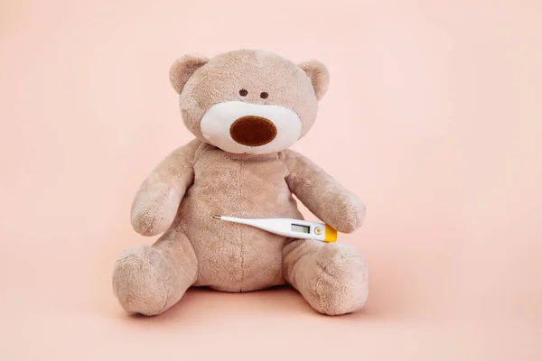 Stuffed Bear animal presented as a pediatrician holding a thermometer with copy space