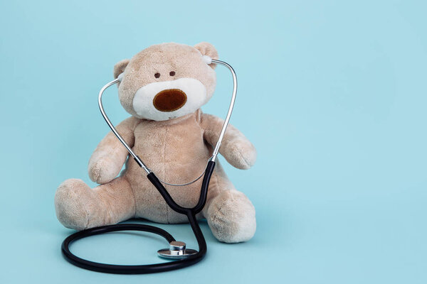 Pediatrician concept. Stuffed Bear animal presented as a pediatrician holding a stethoscope with copy space