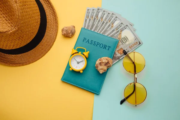 Concetto vacanza estiva. Occhiali da sole, cappello e passaporto con banconote in denaro su sfondo giallo blu — Foto Stock