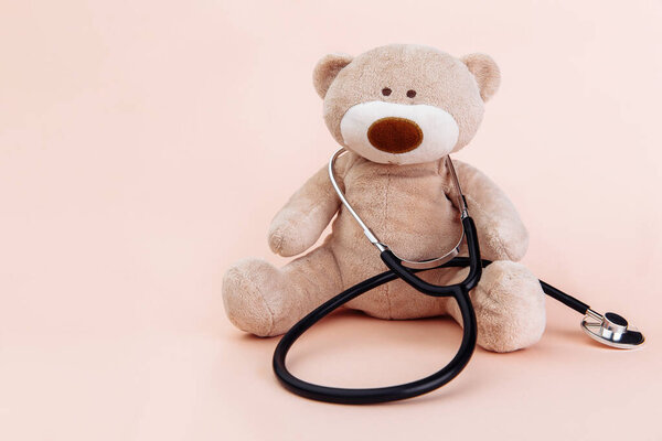 Stuffed Bear animal presented as a pediatrician holding a stethoscope with copy space