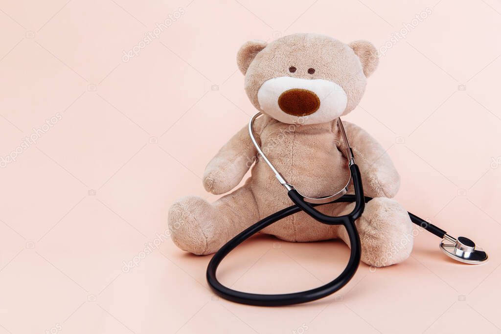 Stuffed Bear animal presented as a pediatrician holding a stethoscope with copy space