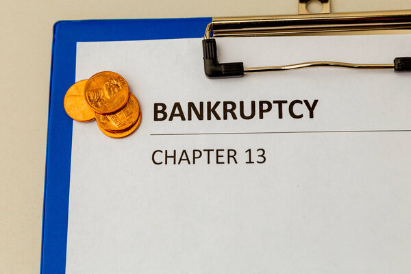 Петиция о банкротстве и несколько монет за столом переговоров.