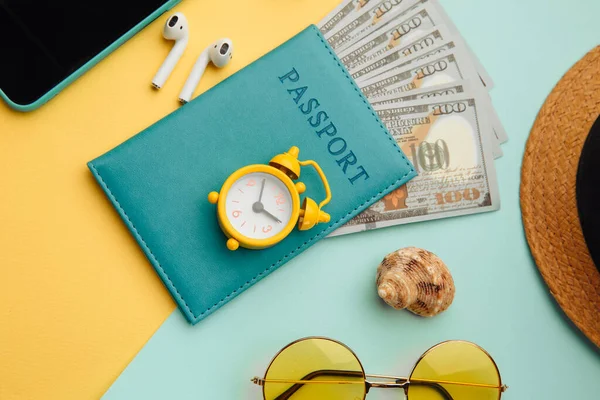 Concepto turístico. Gafas de sol, smartphone, sombrero y pasaporte sobre fondo azul amarillo —  Fotos de Stock