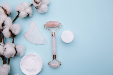 Mavi masadaki pembe tekerlekli masaj aleti ve guaj kazıyıcısı. Yaş, kaldırma ve ton tedavisi kavramı