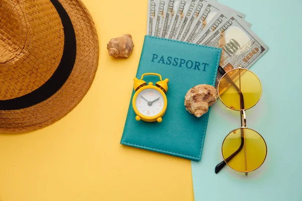 Conceito de férias. Mínimo simples flat lay com passaporte, óculos de sol, chapéu e concha no fundo azul amarelo. Essenciais turísticos — Fotografia de Stock