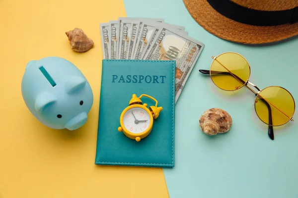 Seyahat aksesuarları ve kumbaraları mavi sarı arka planda. Yolculuk için para biriktir. — Stok fotoğraf