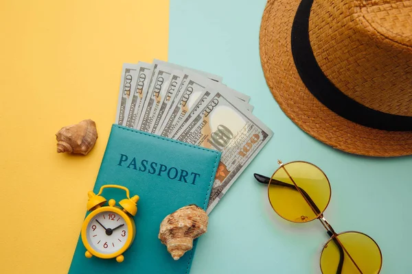 Vacaciones viaje aventura concepto de viaje. Mínimo plano simple con sombrero, pasaporte y concha sobre fondo azul amarillo. Aspectos esenciales del turismo —  Fotos de Stock
