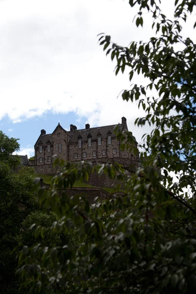 夏の日に前景に木々が植え付いているスコットランドのエディンバラ城 ロイヤリティフリーのストック写真