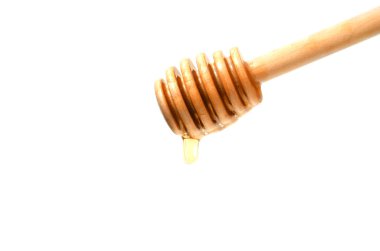 Beyaz zemin üzerine bal için kaşık. Tatlım, tahta kaşık aşağı akar. Yakın çekim.