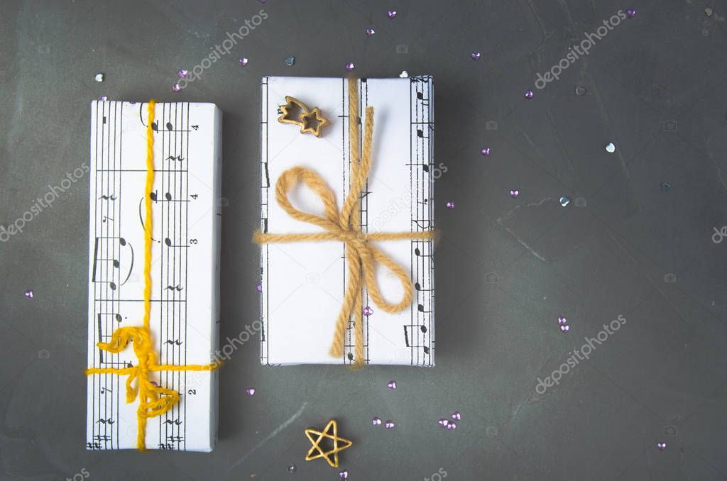 Gifts wrapped in paper with the image of music. Christmas holiday, womens day for the musician.Overhand.