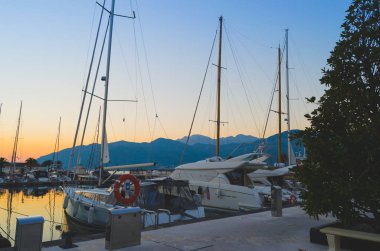 Yatlar akşam gün batımını arka plan üzerinde limanda palamarla. Yüzme ve seyahat.