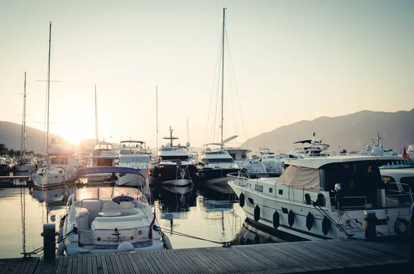 在山区和日落的背景下 在亚得里亚海港口停泊着船只和游艇 港口的日落 — 图库照片