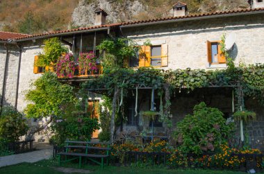 Çiçek ve yeşillik ile dekore edilmiş, cephe ve balkon eski manastır bir kırmızı kiremitli çatı yaz aylarında.