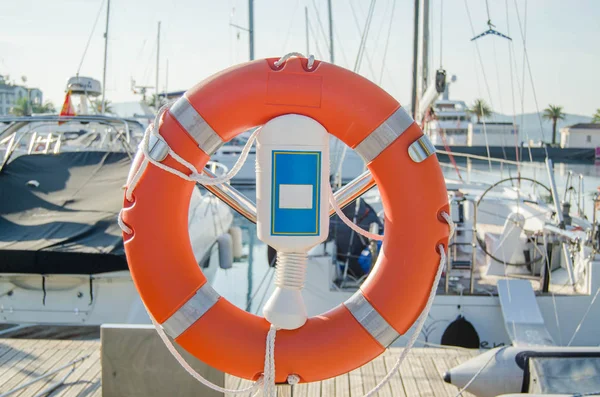 Oranje Reddingsboei Haven Achtergrond Van Jachten Boten Een Zonnige Dag — Stockfoto