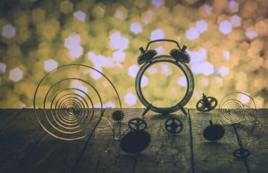 Kırık çalar saat yaylar ve dişli ile parlak ışık arka plan üzerinde dağınık.