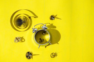 Eski çalar saat vites sert gölgeler bir parlak sarı zemin üzerine içine demonte. Üstten görüntülemek.