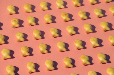 Sert gölgeler ile parlak ışık pembe bir arka plan üzerinde balık şeklinde kurabiyeler. Yakın çekim.