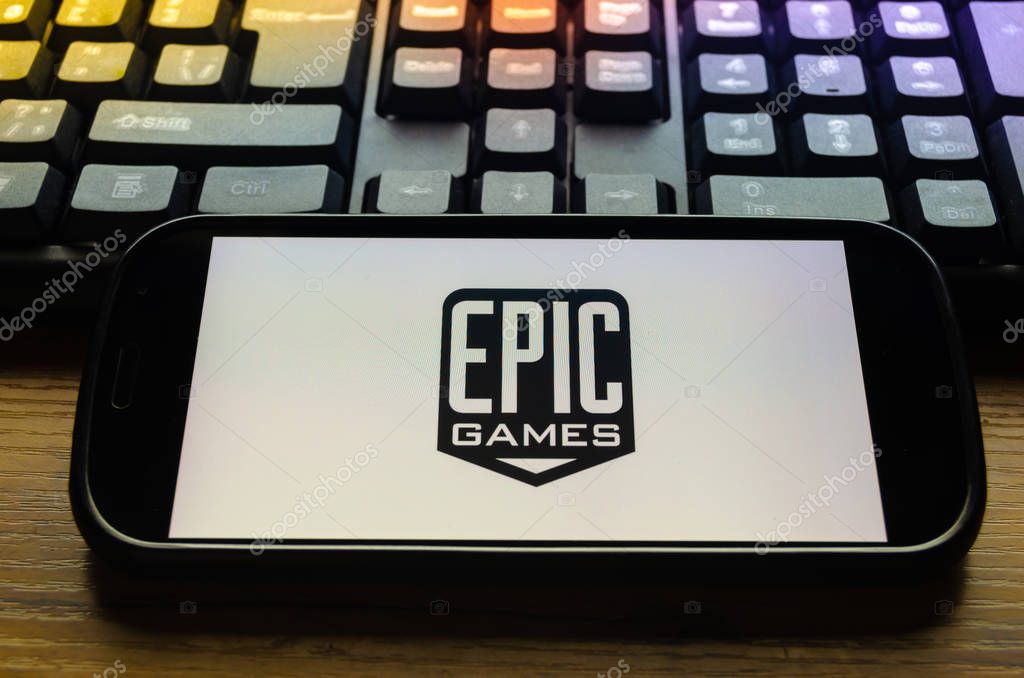 Mobile phone on the background of the keyboard, with the screen logo of the company Epic Games has created a popular game Fortnite.
