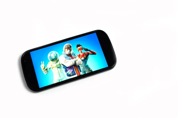Kostanay, Kasachstan, auf weißem Hintergrund Mobiltelefon mit Bild des beliebten Spiels Fortnite. — Stockbild Kostanay Kasachstan Auf Weißem Hintergrund Mobiltelefon Mit Bild Des Beliebten — Stockfoto