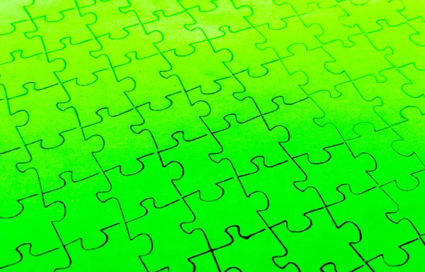 明るい緑の背景に組み立てパズル — ストック写真