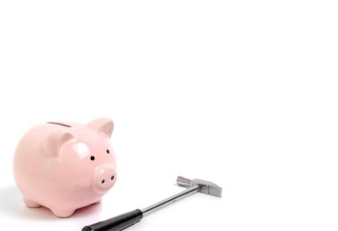 Pembe kumbara ve beyaz arka plan üzerinde küçük çekiç. Finans, tasarruf ve iş.