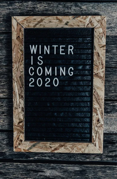 Panneau à lettres avec lettrage blanc l'hiver arrive sur un vieux fond en bois . — Photo