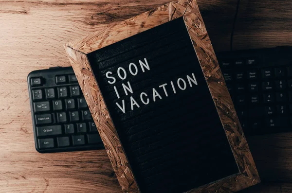Brieftafel, die auf der Tastatur mit weißer Aufschrift auf schwarz liegt, ist bald im Urlaub. — Stockbild Brieftafel, die auf der Tastatur mit weißer Aufschrift auf schwarz liegt, ist bald im Urlaub. — Stockfoto