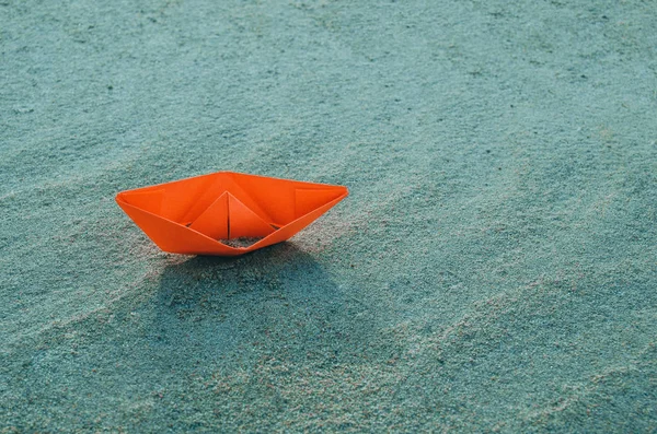 Rotes Papierboot auf dem Grund eines trockenen Meeres. Strand, Hitze und Urlaub. Ökologie, Dürre. — Stockfoto