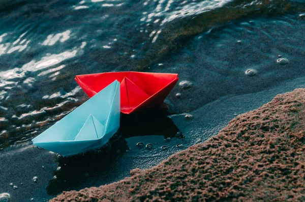 Δύο χάρτινες βάρκες με μπλε και κόκκινο χρώμα στην αμμώδη παραλία. Ζευγάρι και ρομαντισμός. — Φωτογραφία Αρχείου